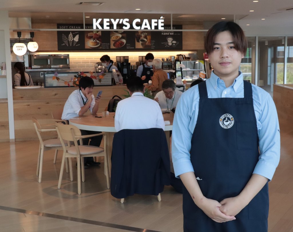 浅野撚糸に2023年春入社した武蔵優貴さん。「接客など人と話すのが好きなので、将来は営業にも挑戦したい」と意気込む。施設に併設されているカフェにて