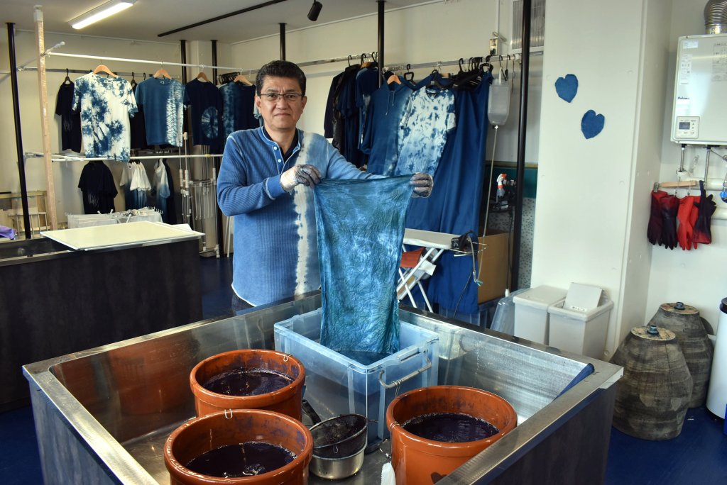 「藍染結の杜」で藍染め体験施設を案内する水野染工場の水野弘敏社長。気軽にオリジナル作品が作れる